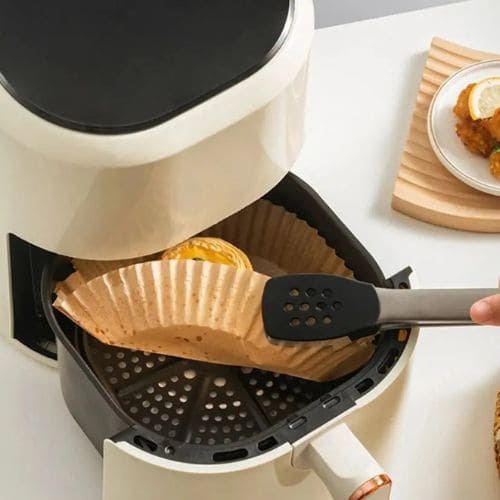 Disposable air fryer paper liners designed to help prevent food residue from sticking to the basket.